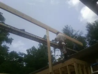 Carpenter setting a ridge beam over a new addition frame — Ice Dam Removal by Roofing Brothers in Woodville
