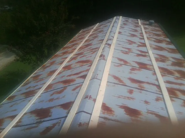 Rusted metal roof panels with new wood purlins before replacement — Storm Damage Roof Repair in Woodville by Roofing Brothers