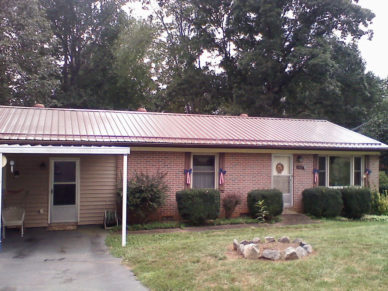 Bronze metal roof and carport on a brick ranch home — Roof Repair work by our crew in Woodville